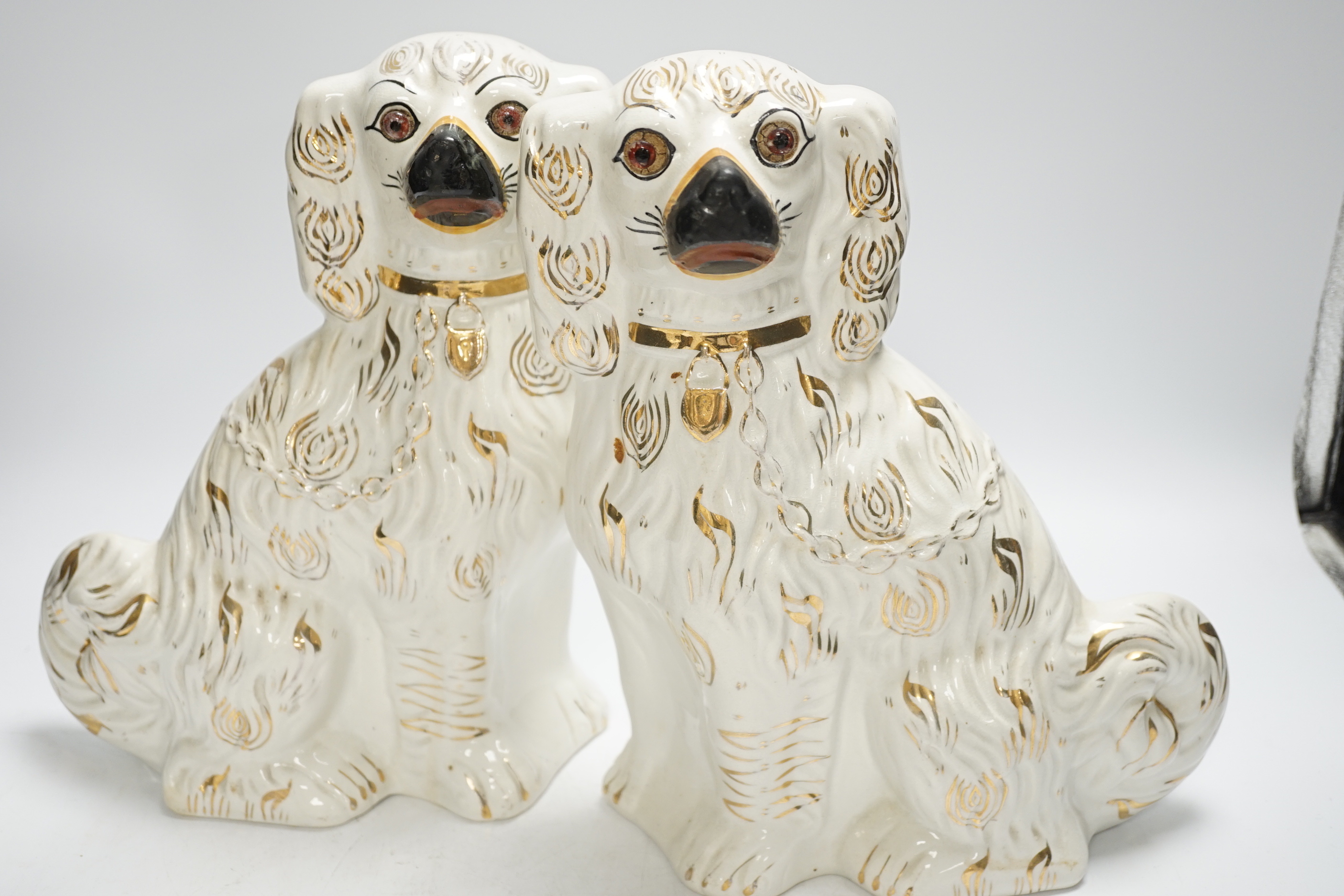 Two pairs of Victorian Staffordshire chimney spaniel dogs, largest 29cm high